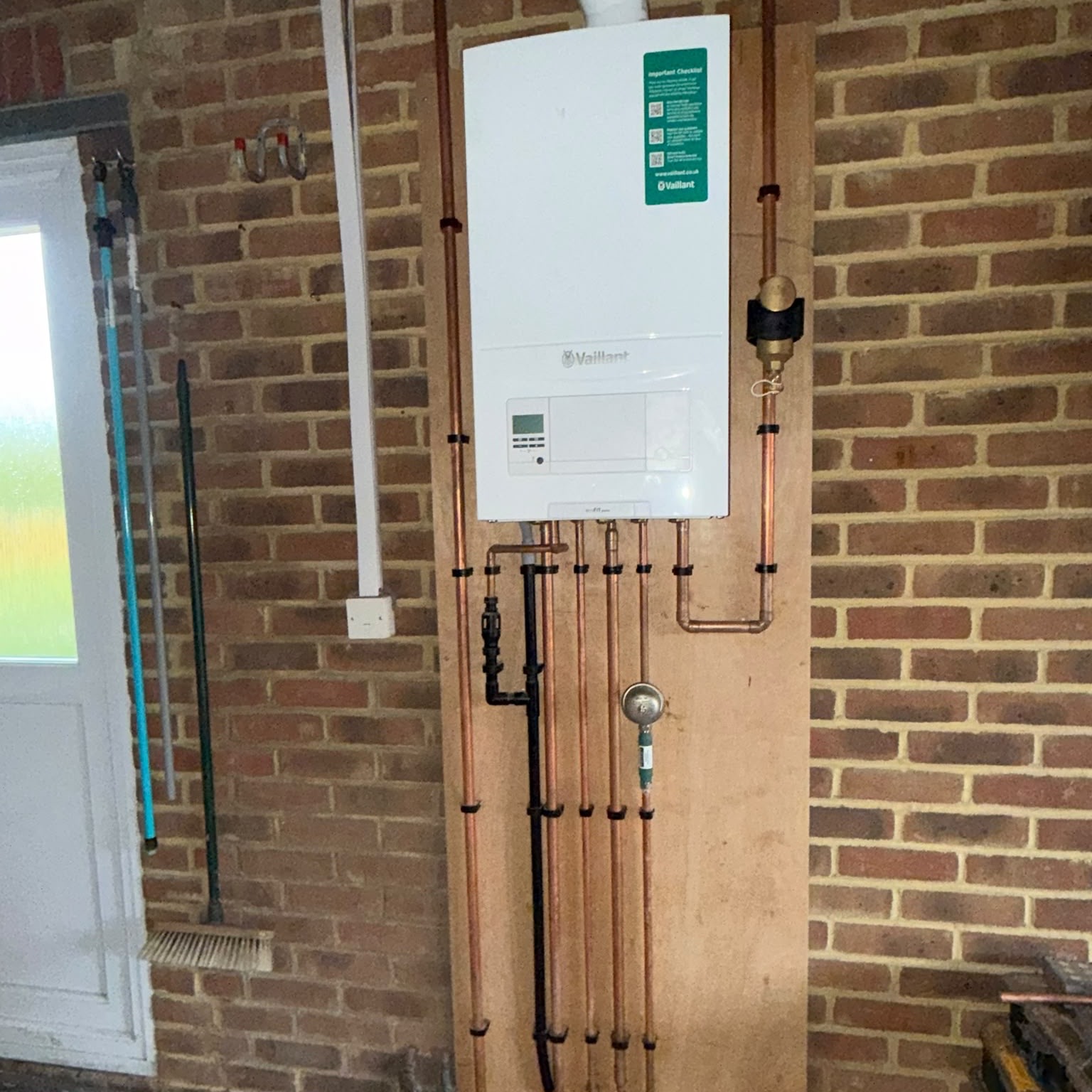 Modern boiler installation with neatly arranged pipework